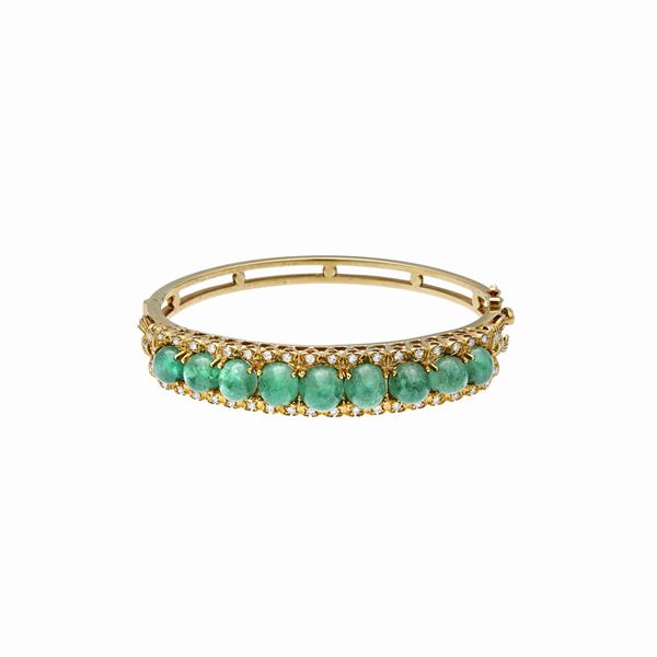 Bangle in yellow gold, diamonds and emeralds