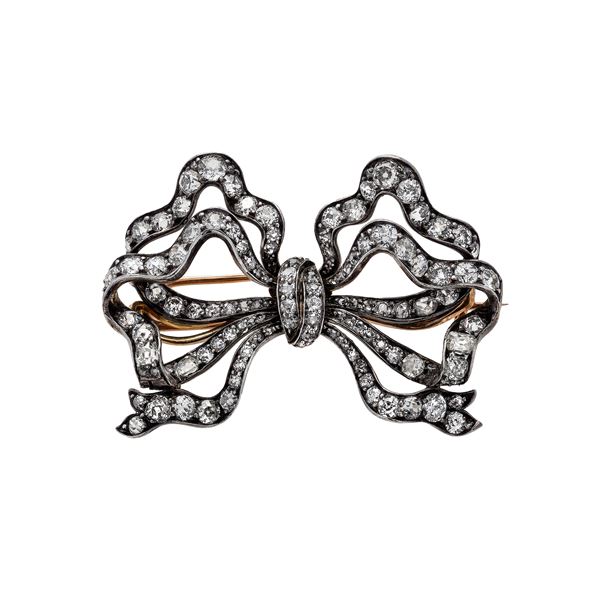 Bow brooch in yellow, silver and diamonds gold