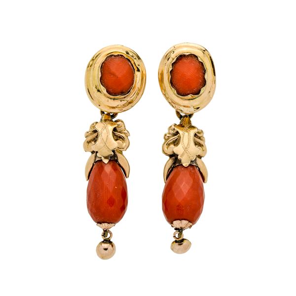 Pair of dangling earrings in yellow gold and red coral