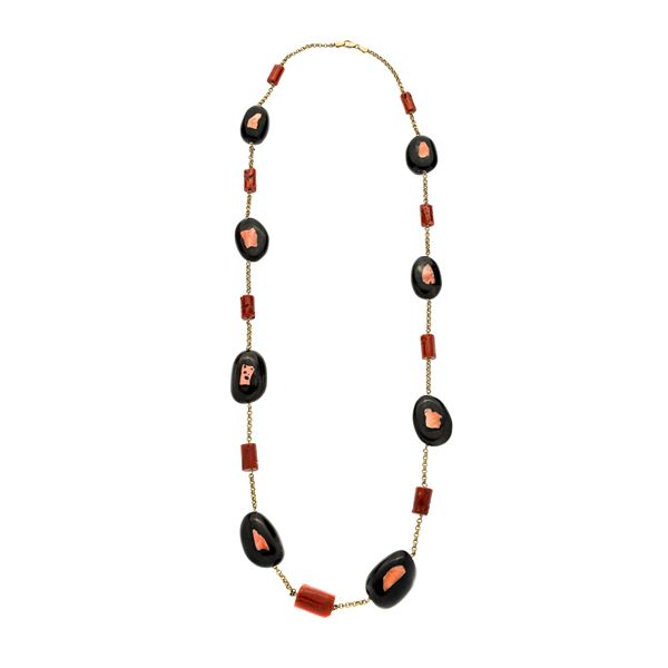 Long necklace in yellow gold, horn and red coral
