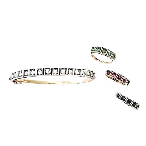 Rigid bracelet and three low-titled gold rings, silver, diamonds, rubies, sapphires and emeralds
