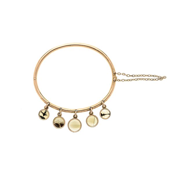 Rigid bracelet in yellow gold with charms