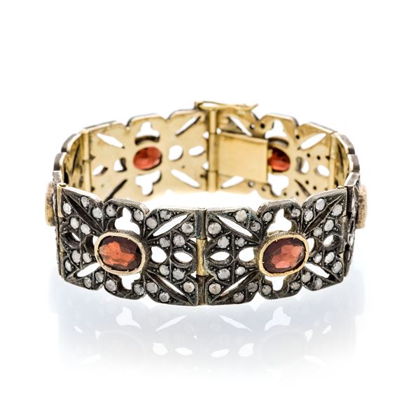 High bracelet in yellow gold, low title gold, silver, diamonds and garnets