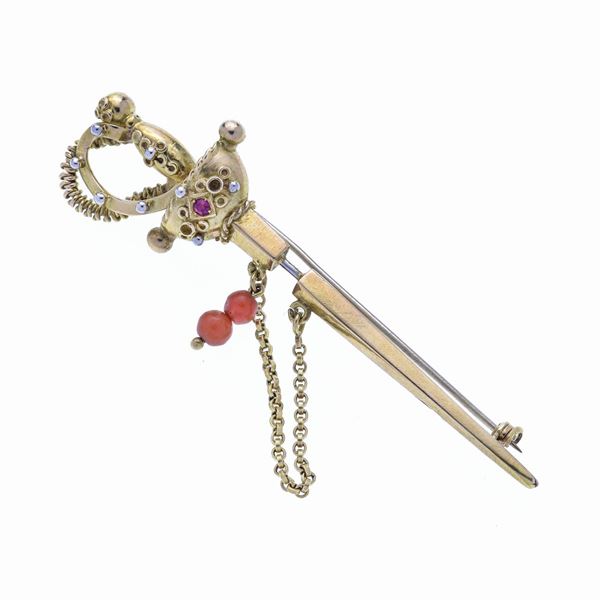 Spada brooch in yellow gold, coral and red stone