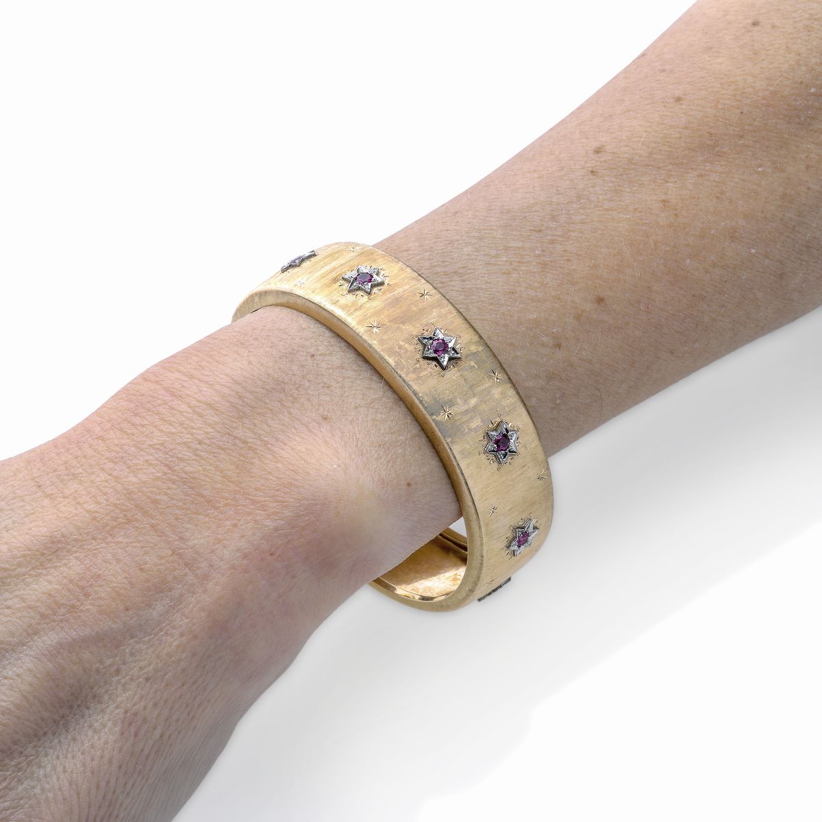 Bracciale rigido in oro giallo, oro bianco e pietre rosse