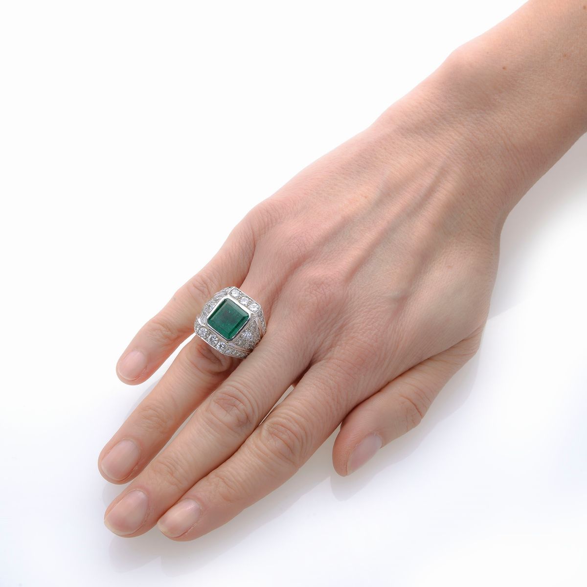 Grande anello a fascia in oro bianco, diamanti e smeraldo