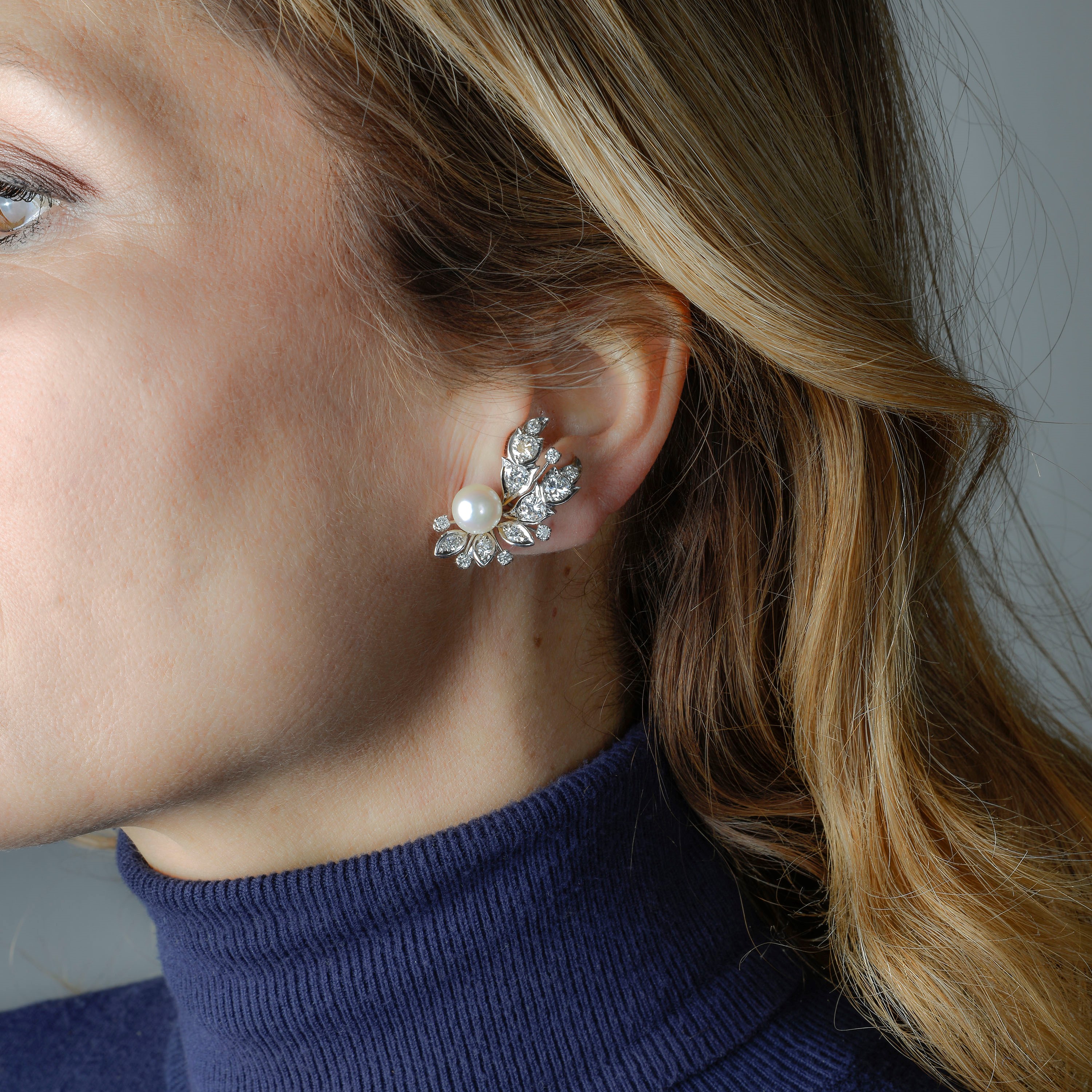 Paio di orecchini di ispirazione floreale in oro bianco, diamanti e perle