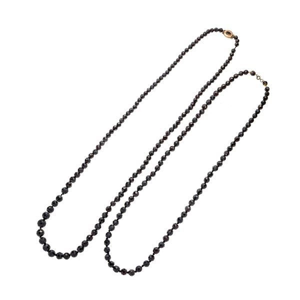 Una lunga collana in granato e oro basso ed un'altra in granato e metallo dorato