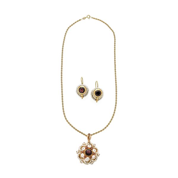 Set in 18 kt yellow gold, low title gold, garnets and micropearls