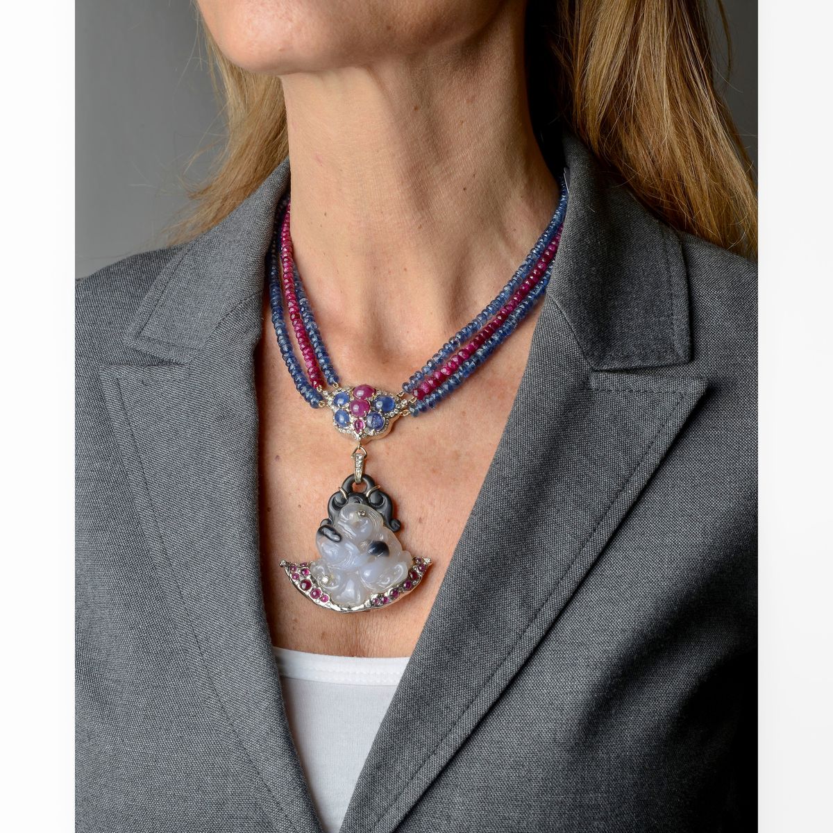Collana in oro bianco, rubini, zaffiri e diamanti con pendente in onice, calcedonio, rubini, diam...
