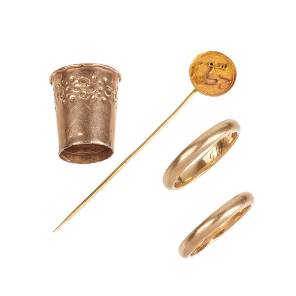 Two wedding rings, a tie pin and a yellow gold thimble