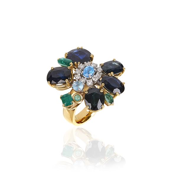 Large flower ring in 18 kt yellow gold, sapphires, emeralds, diamonds and blue stones