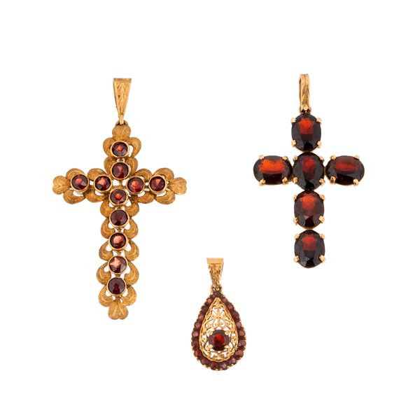 Two 18kt yellow gold and garnet crosses and a similar drop pendant