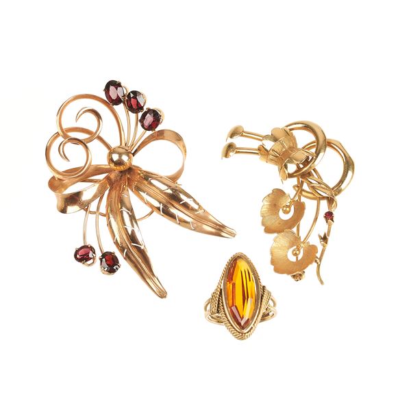 Two floral brooches and ring in 18 kt yellow gold, garnets and orange stone