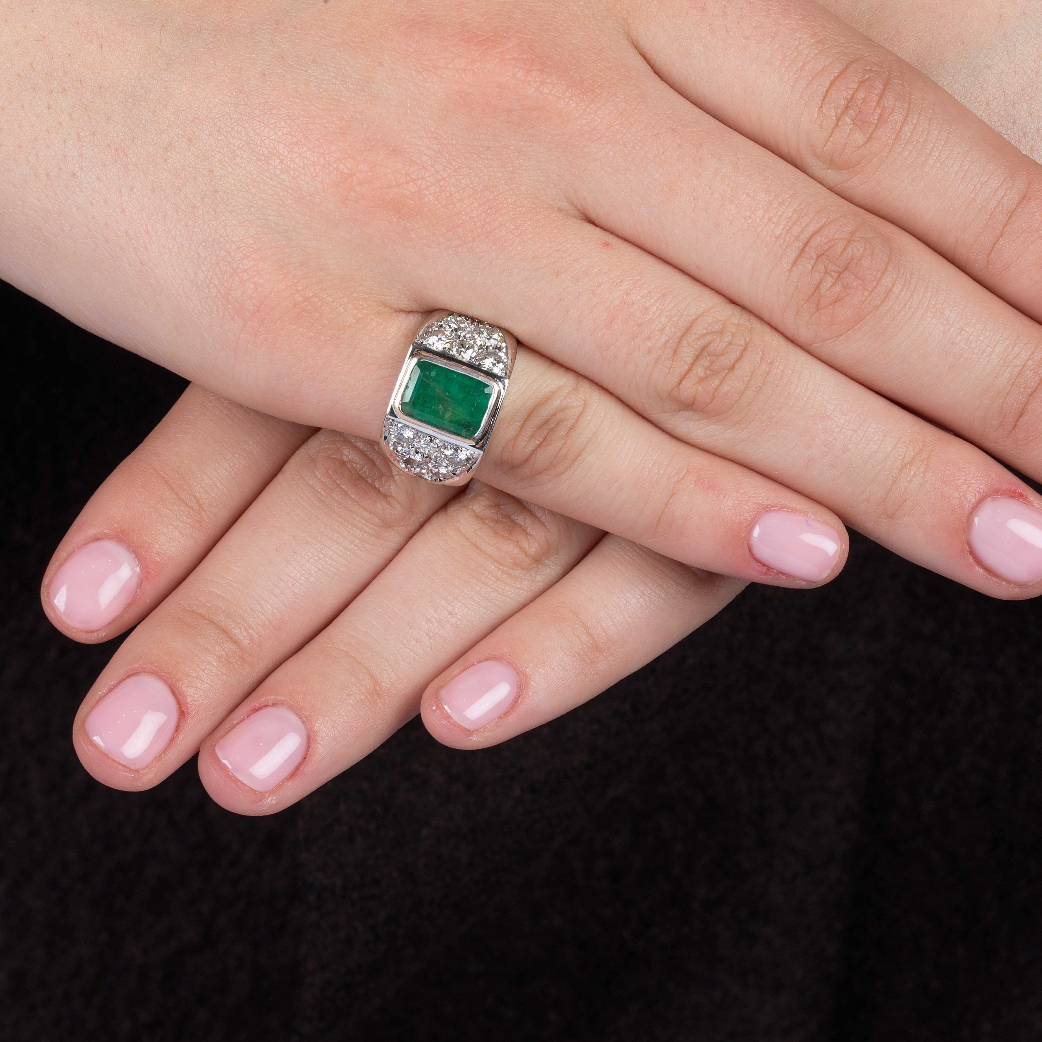 Anello a fascia in oro bianco, diamanti e smeraldo