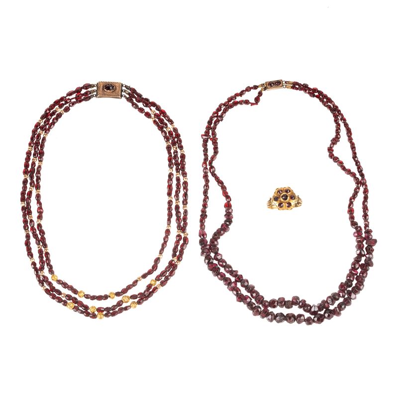 Due girocollo in oro basso e granati e un anello in oro basso e pietre rosse