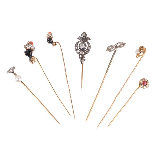 Sette splle da cappello e cravatta in oro 18 kt, oro basso, argento, diamanti, smalti, corallo