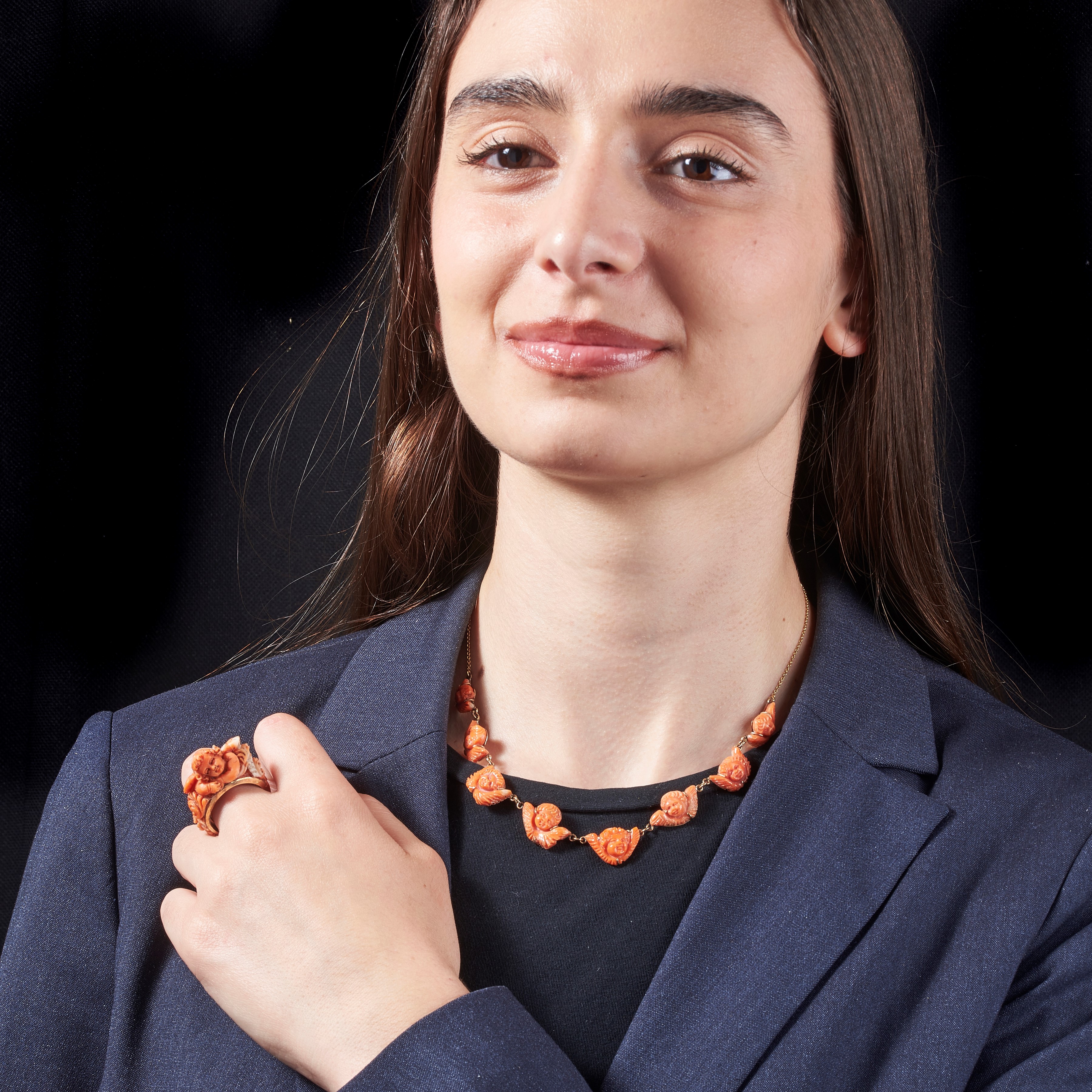 Parure Amorini composta da orecchini, collier e anello in oro giallo 18 kt e corallo rosa inciso