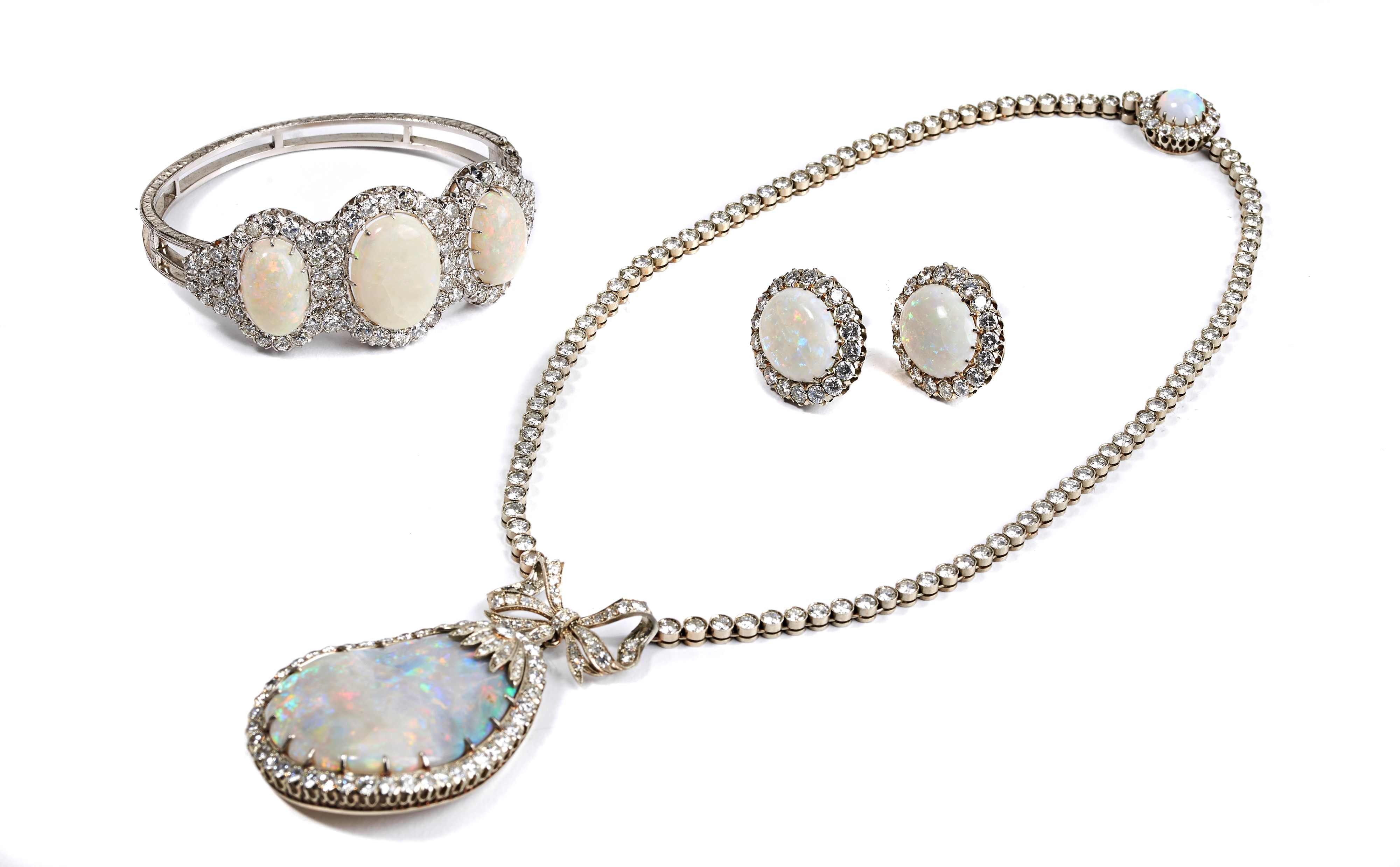 Importante parure composta da orecchini, collier, bracciale, anello in oro bianco, diamanti e opa...