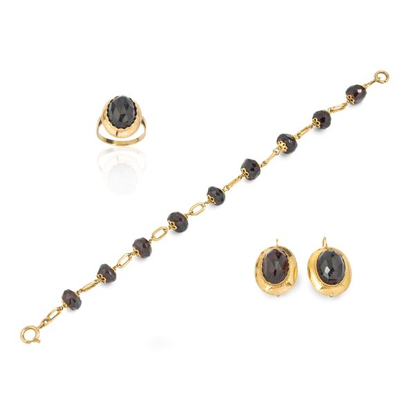 Paio di orecchini, anello e bracciale in oro giallo 18 kt e granato
