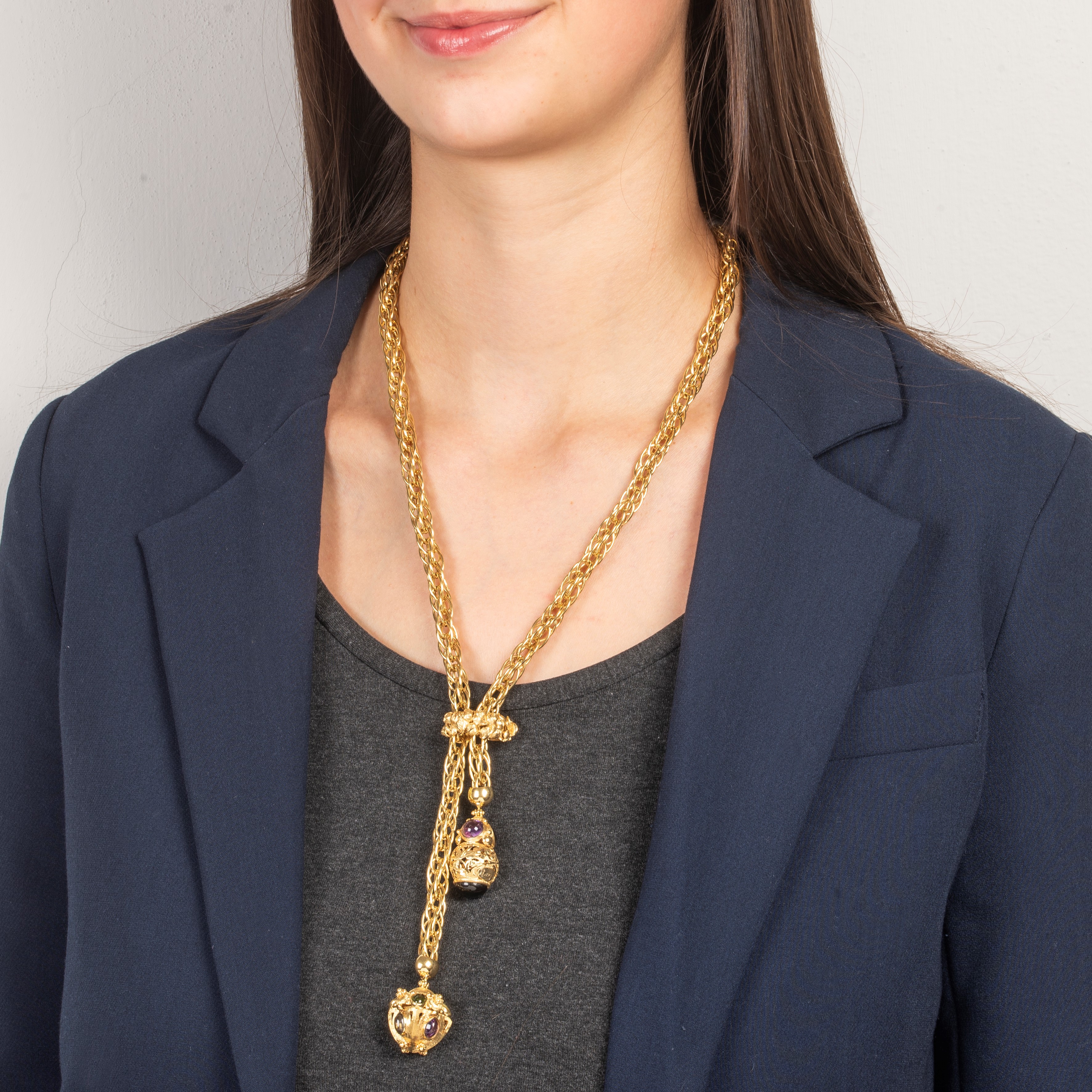 Lunga collana tubolare saliscendi in oro giallo 18 kt con due chrms con pietre dure