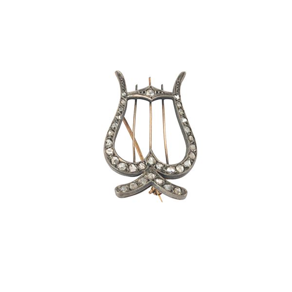 Brooch made like a lyre in low title gold, silver and diamonds