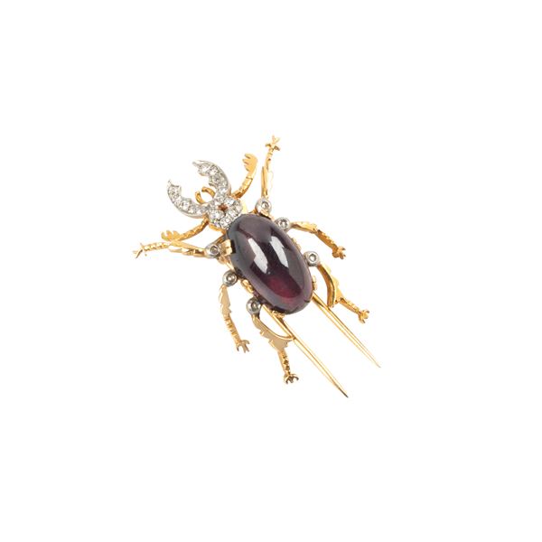 Scarabeo clip in 18 kt yellow and white gold, diamonds and garnet
